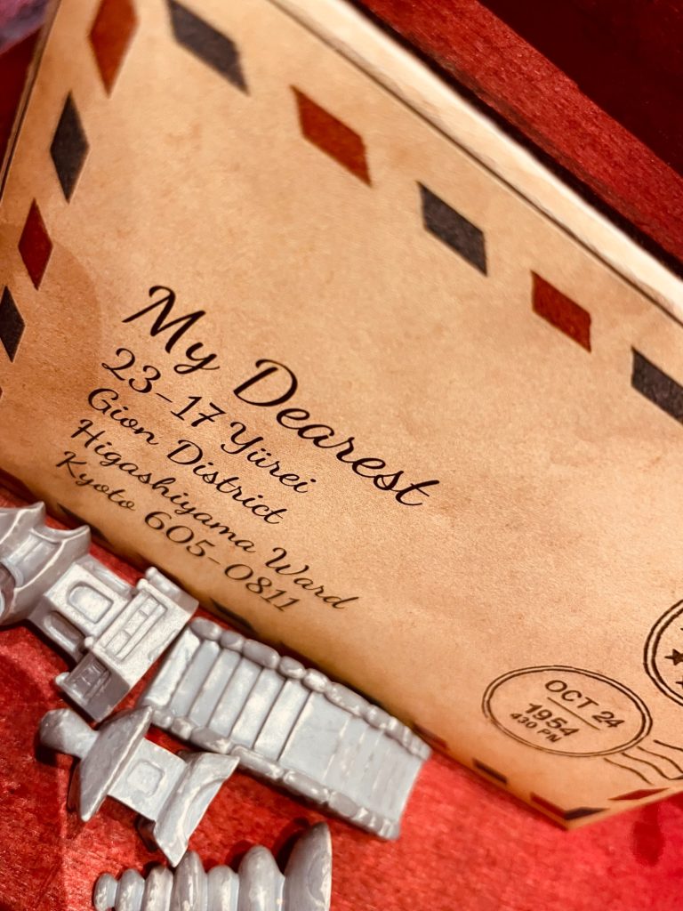 Ett brev adresserat "My Dearest" med vintage-stil och leksaksfigurer i bakgrunden.